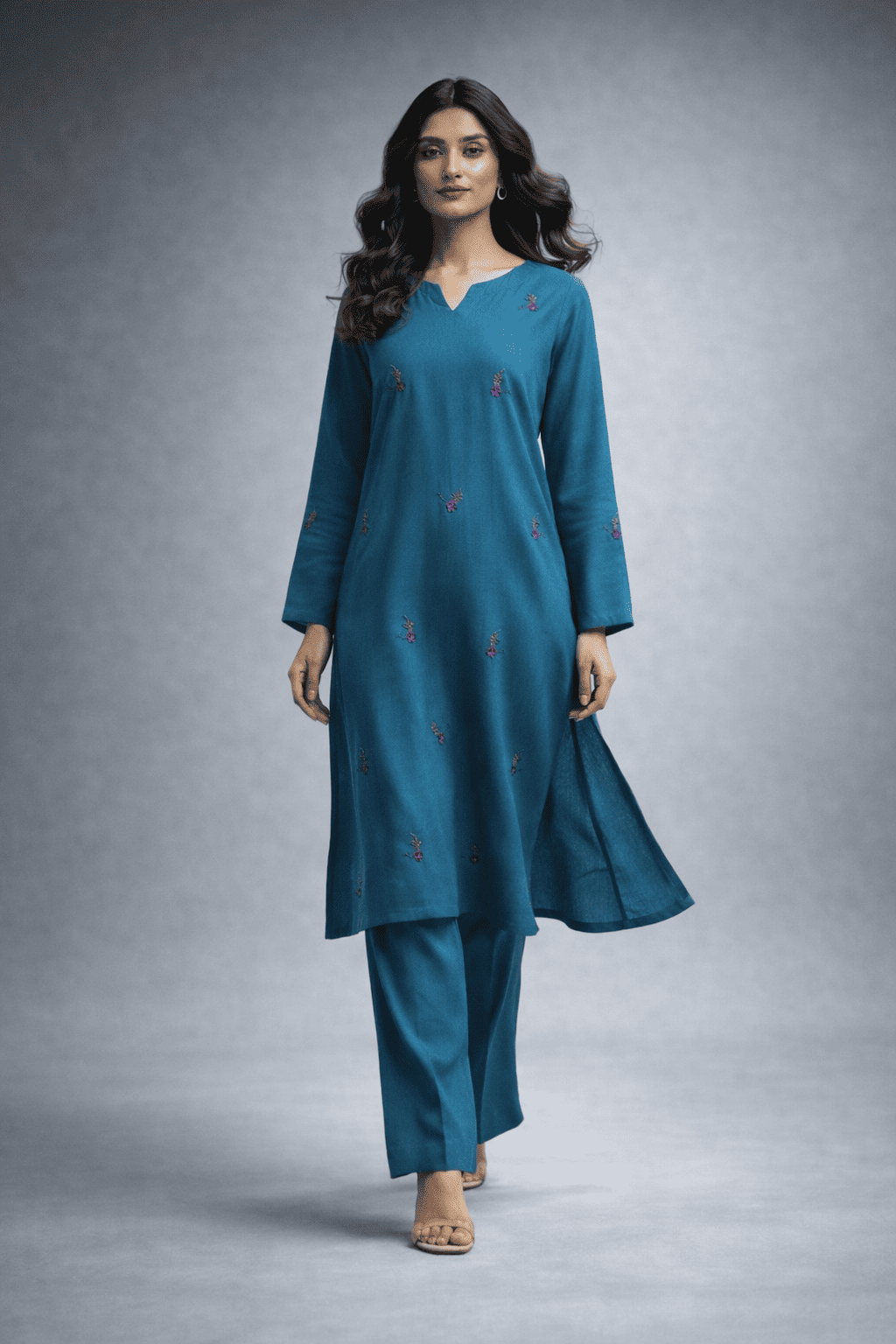 Woman wearing a teal traditional outfit with a plain background