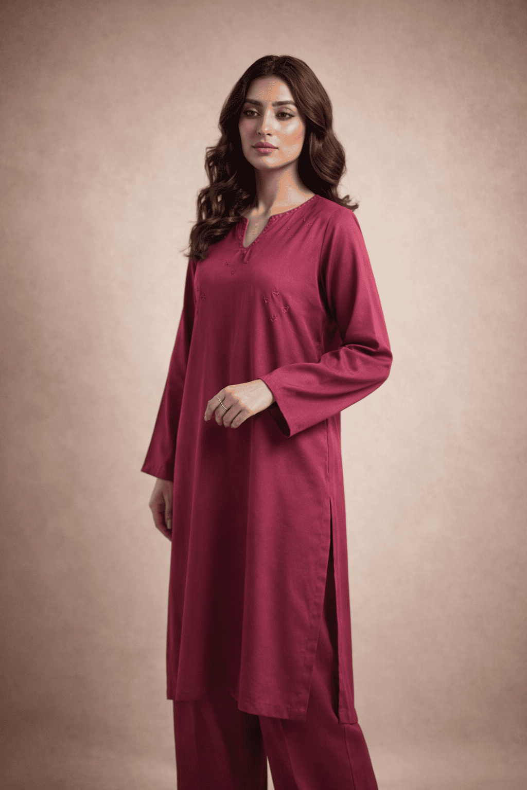 Pakistani woman model wearing elegant deep pink winter kurta with matching trousers, minimalist studio background, premium stitched pret outfit