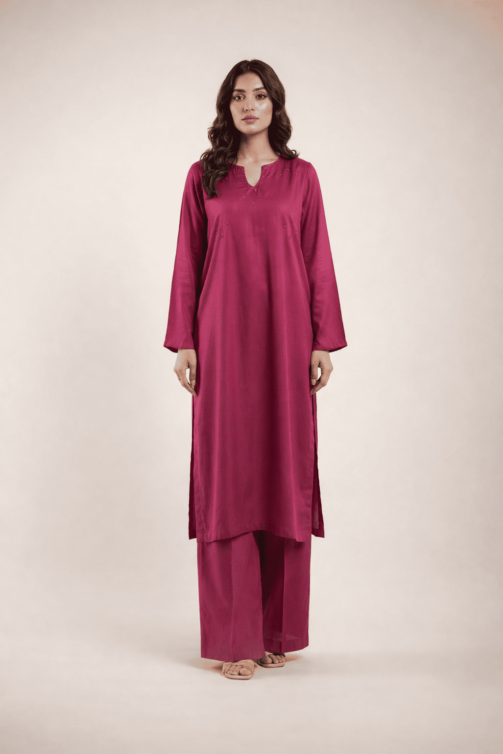 Woman wearing a magenta outfit on a plain background